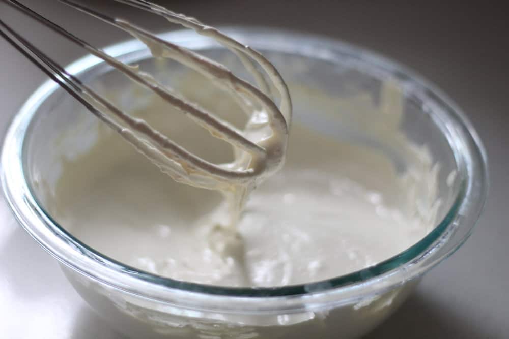 whisk coming out of a bowl with homemade sunscreen