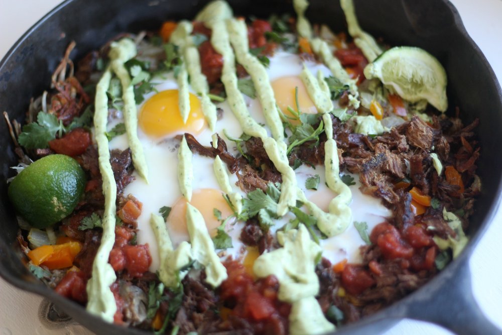 Mexican hash browns topped with eggs and avocado crema sauce