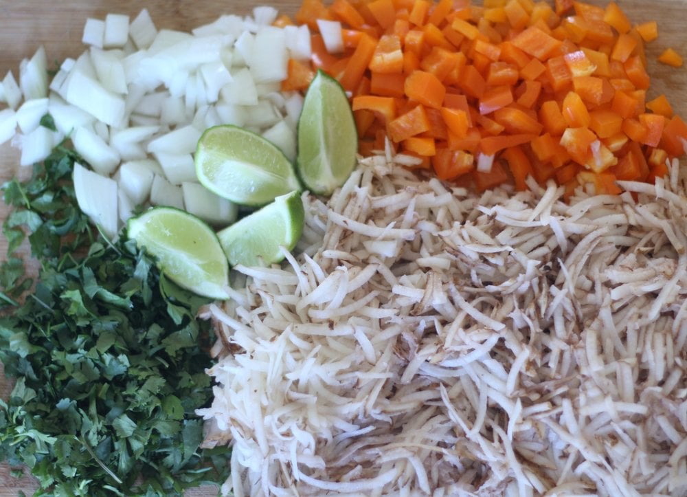 chopped up onions, orange peppers, lime quarter, and shredded potatoes