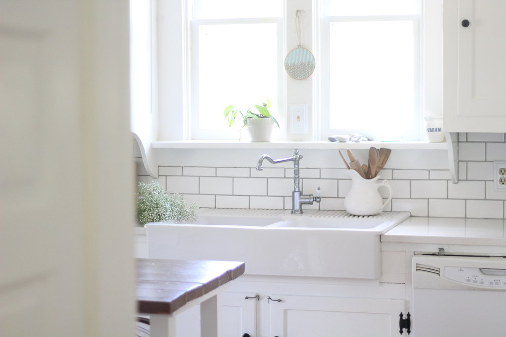 farmhouse kitchen with an ikea farmhouse sink, faucet, and white countertops