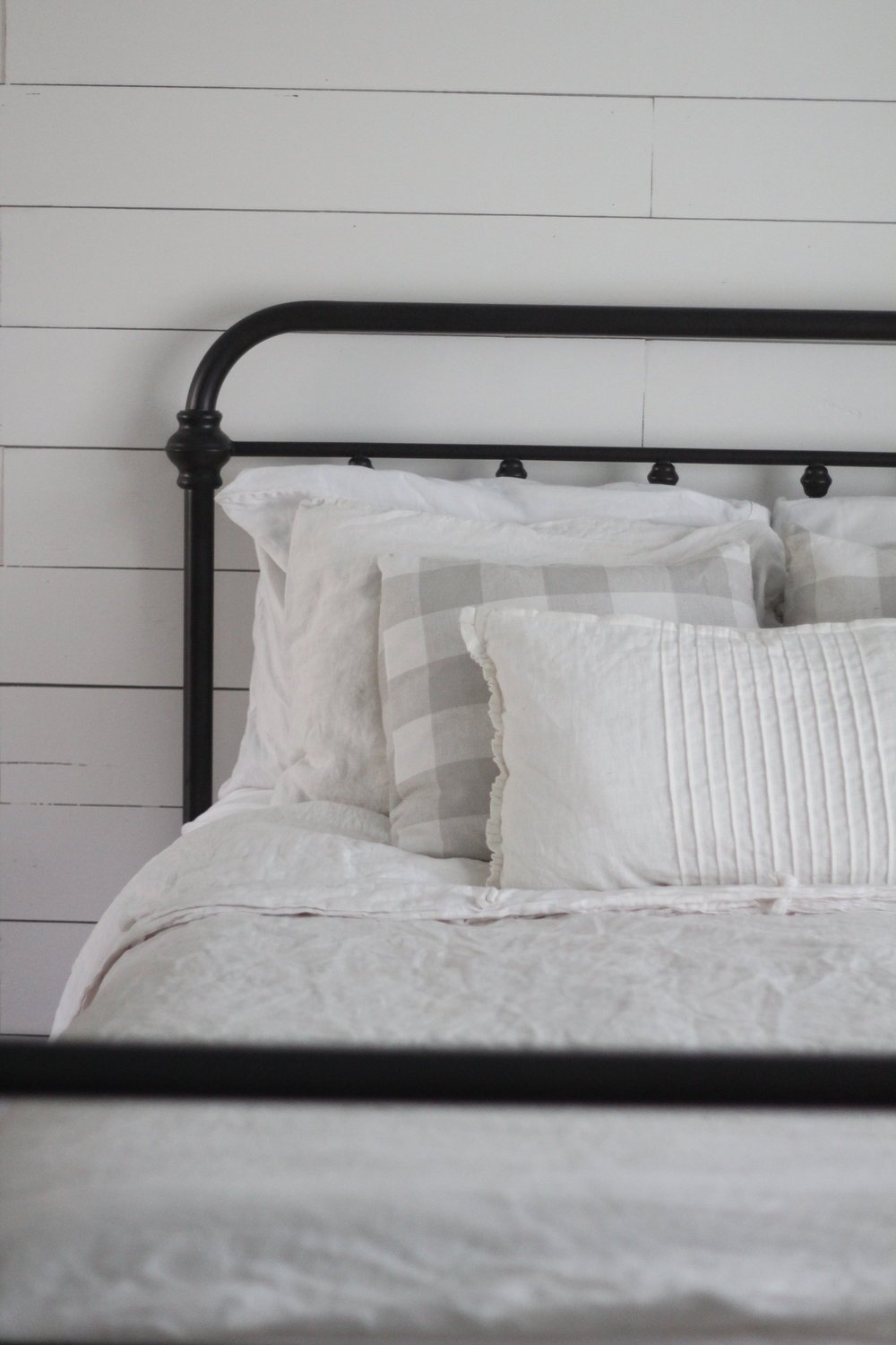 iron bed with linen pillows and duvet covers