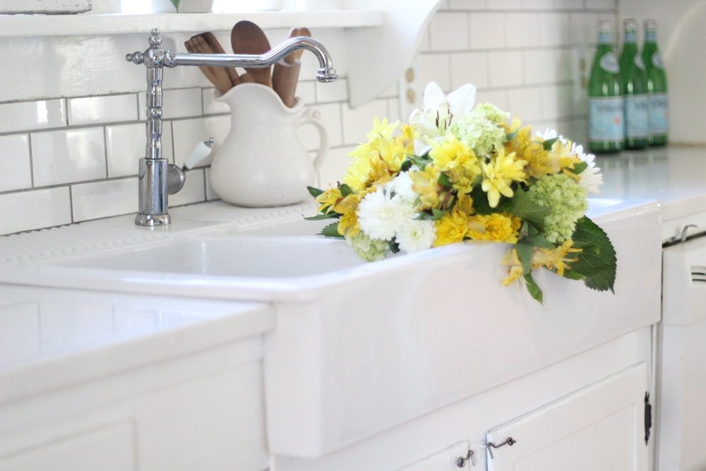 yellow and white flowers in a ikea farmhouse sink.