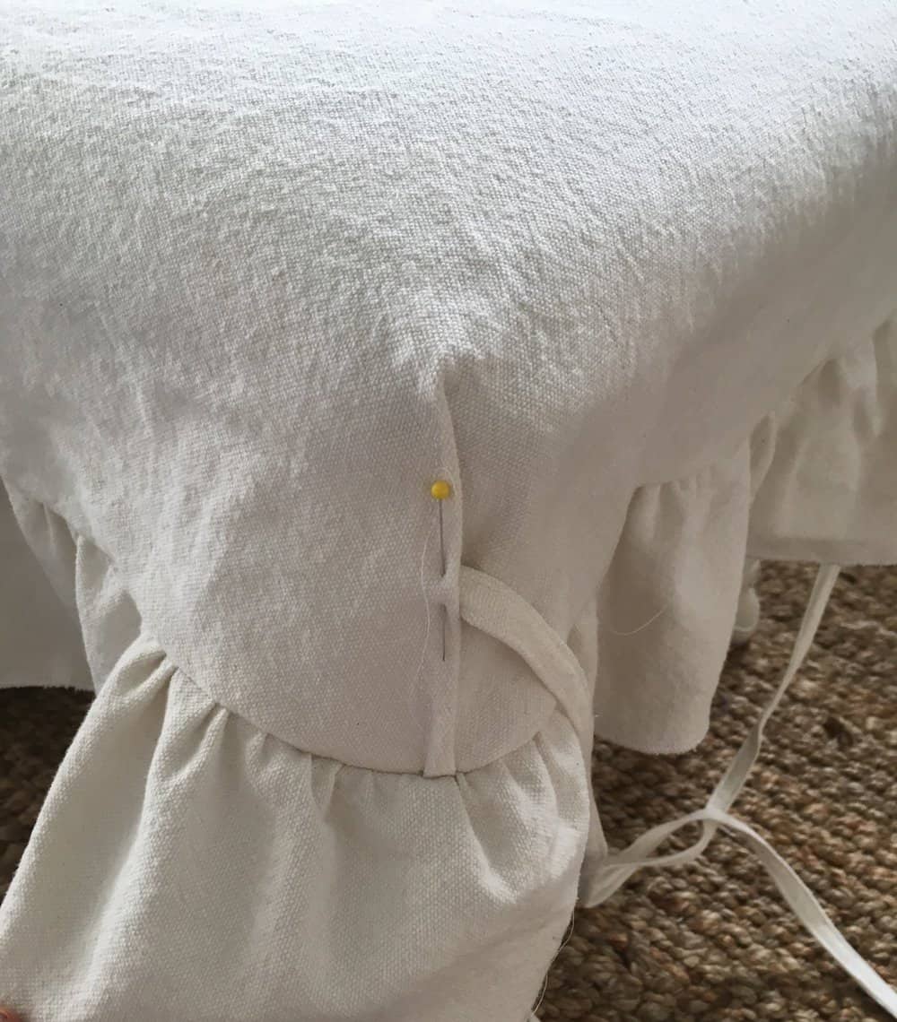 pinning ties to the corners of a drop cloth bench cover