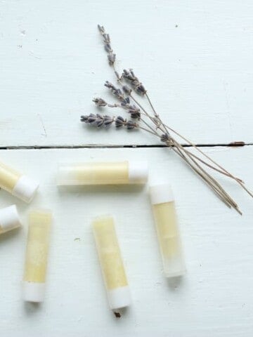 homemade lip balm on a white table with dried lavender
