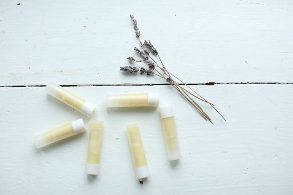 homemade lip balm on a white table with dried lavender