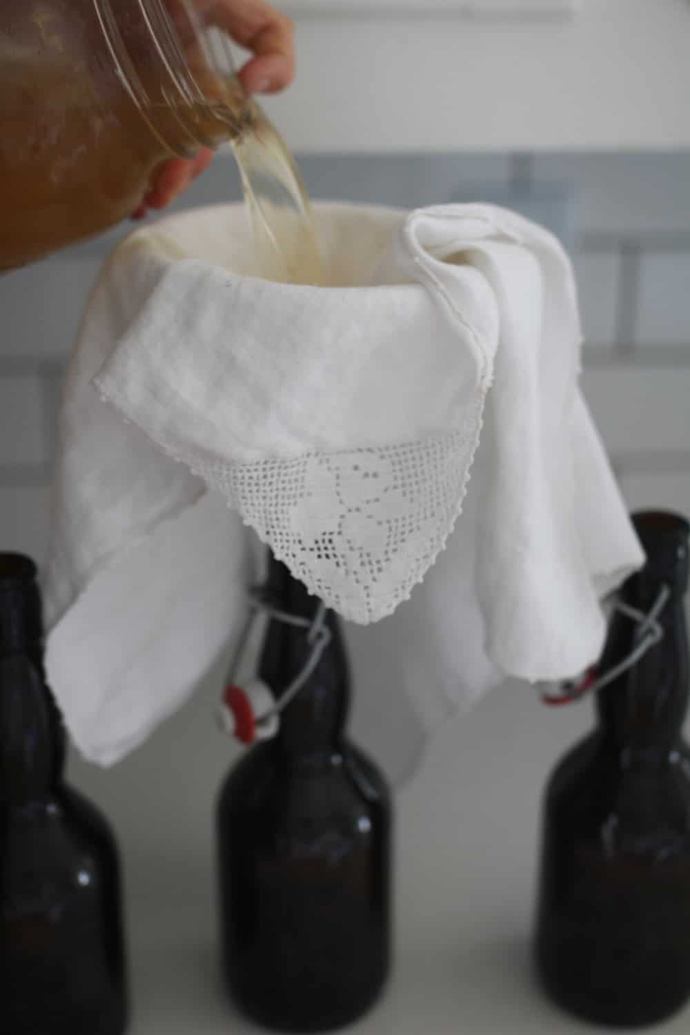 straining water kefir through a cloth to make water kefir soda