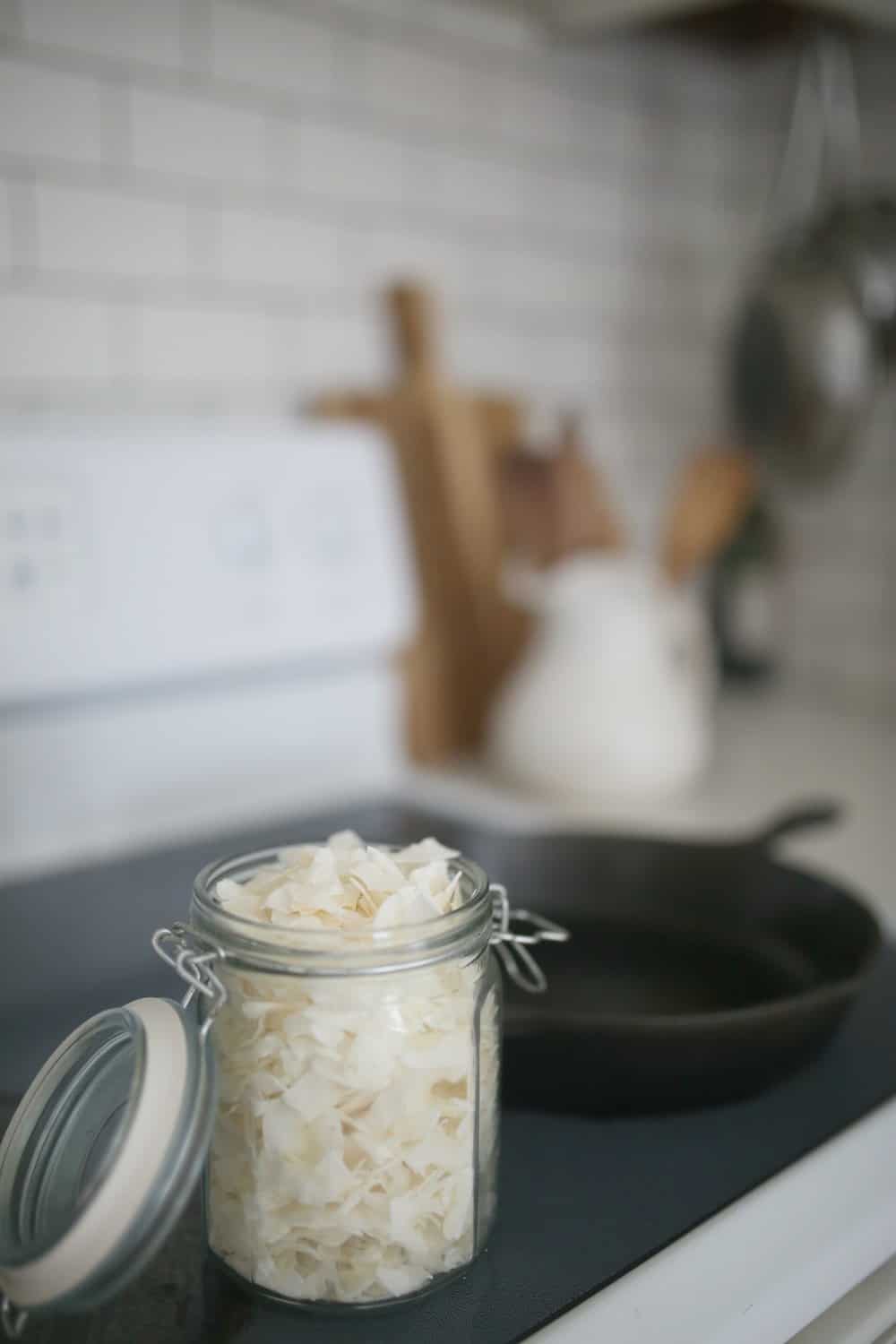 coconut flakes in a glass jar with a swing top lid on a stove-top