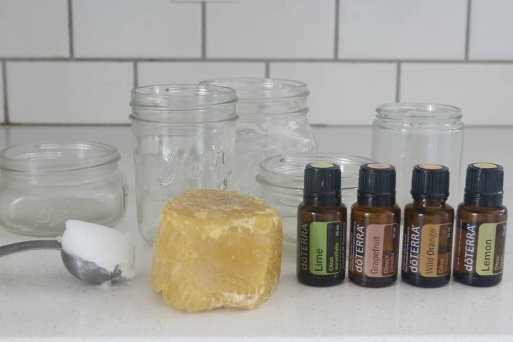 beeswax, coconut oil, essential oil and mason jars on a white countertop