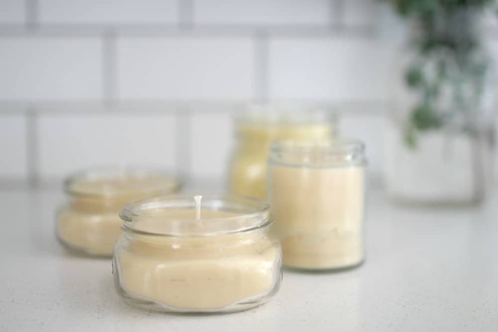 four beeswax candles on a white countertop