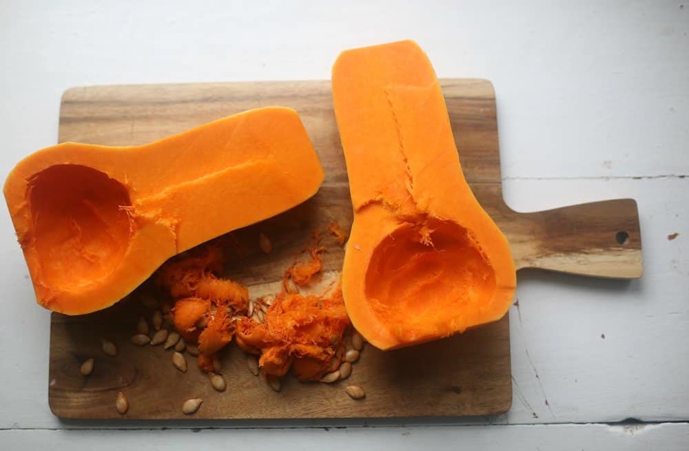 butternut squash sliced in half with seeds taken out on a cutting board