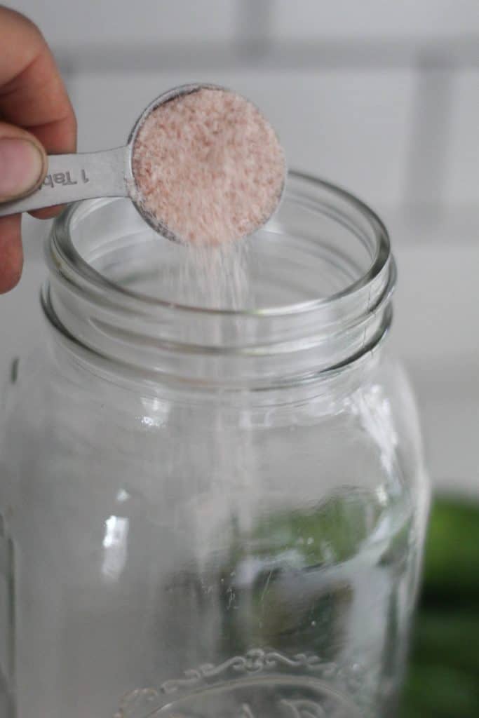 adding salt to a large mason jars