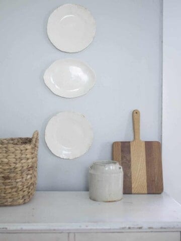 farmhouse plates hanging on a wall above a dresser