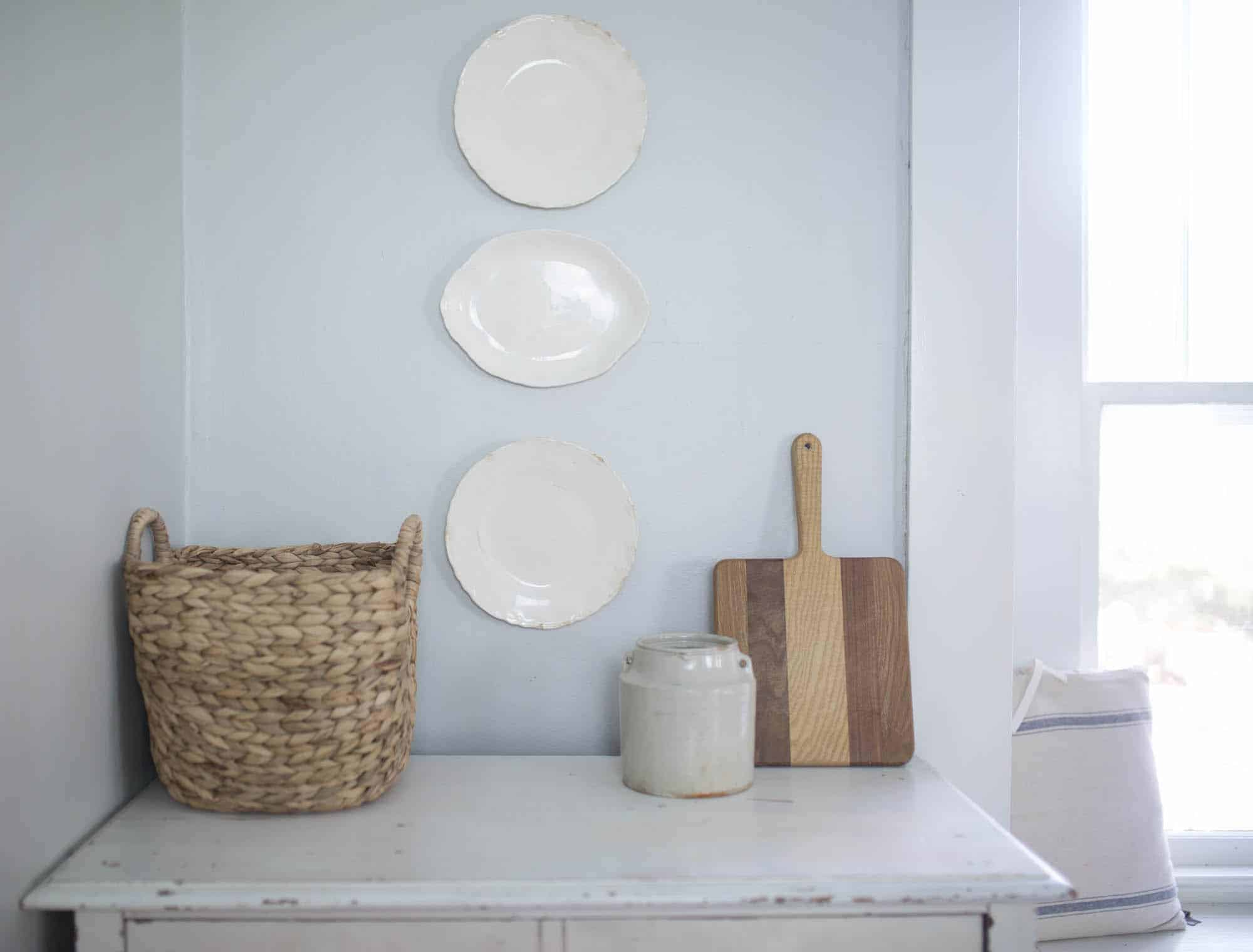 farmhouse plates hanging on a wall above a dresser