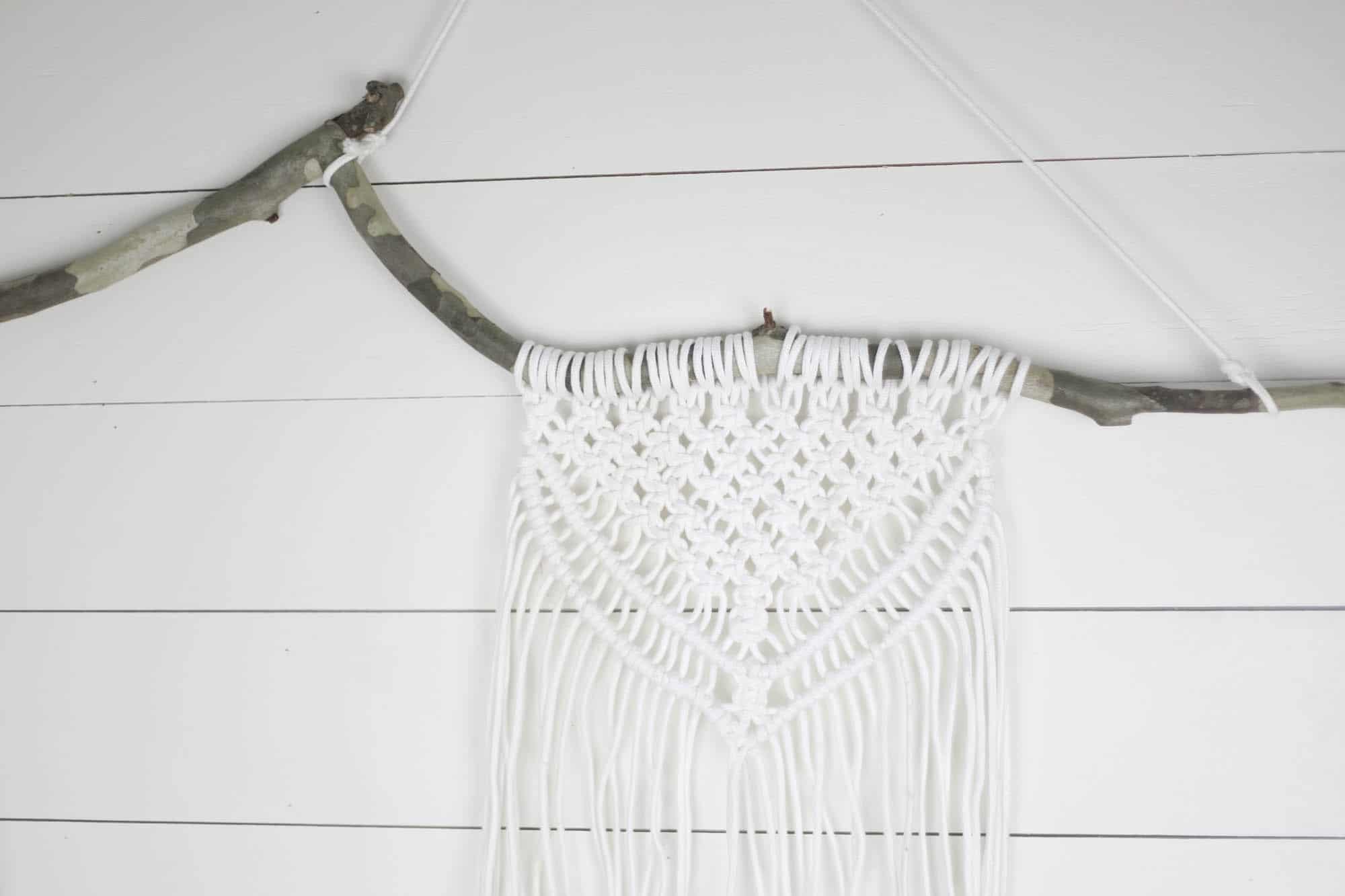 Macrame Wall Hanging using a branch on a shiplap wall