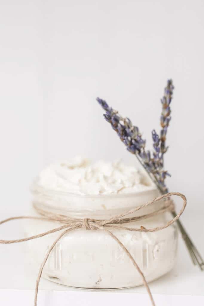 DIY whipped body butter in a short glass mason jar tied with twine and fresh lavender