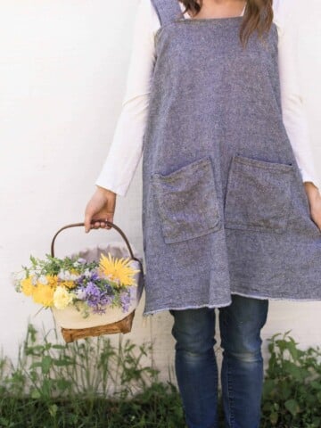 women with a DIY apron holding a basket of flowers