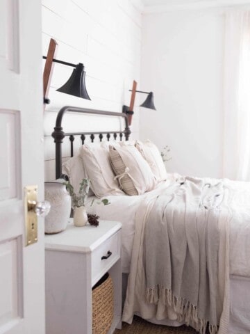 Tour our winter farmhouse bedroom with lots of natural elements like greenery and pine cones.