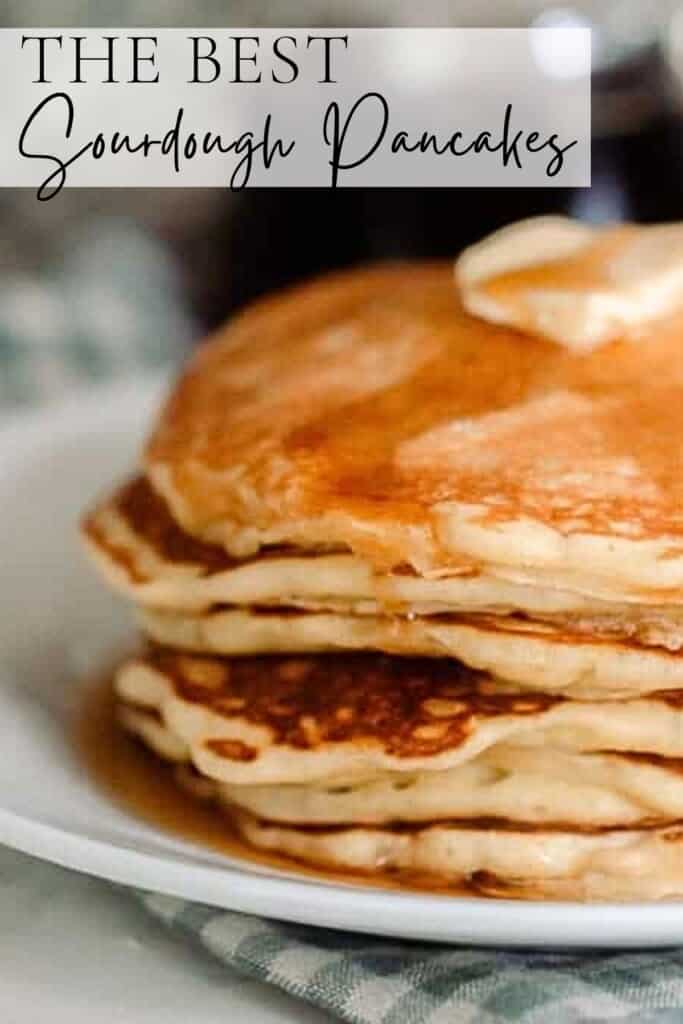 close up photo of half of a stack of sourdough pancakes stacked on a plate and topped with butter and maple syrup