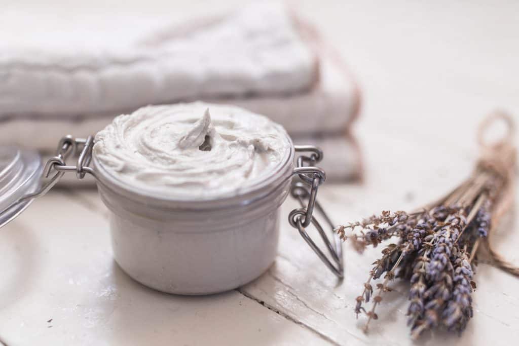 homemade diaper rash cream and sprig of lavender in font of cloth diaper inserts