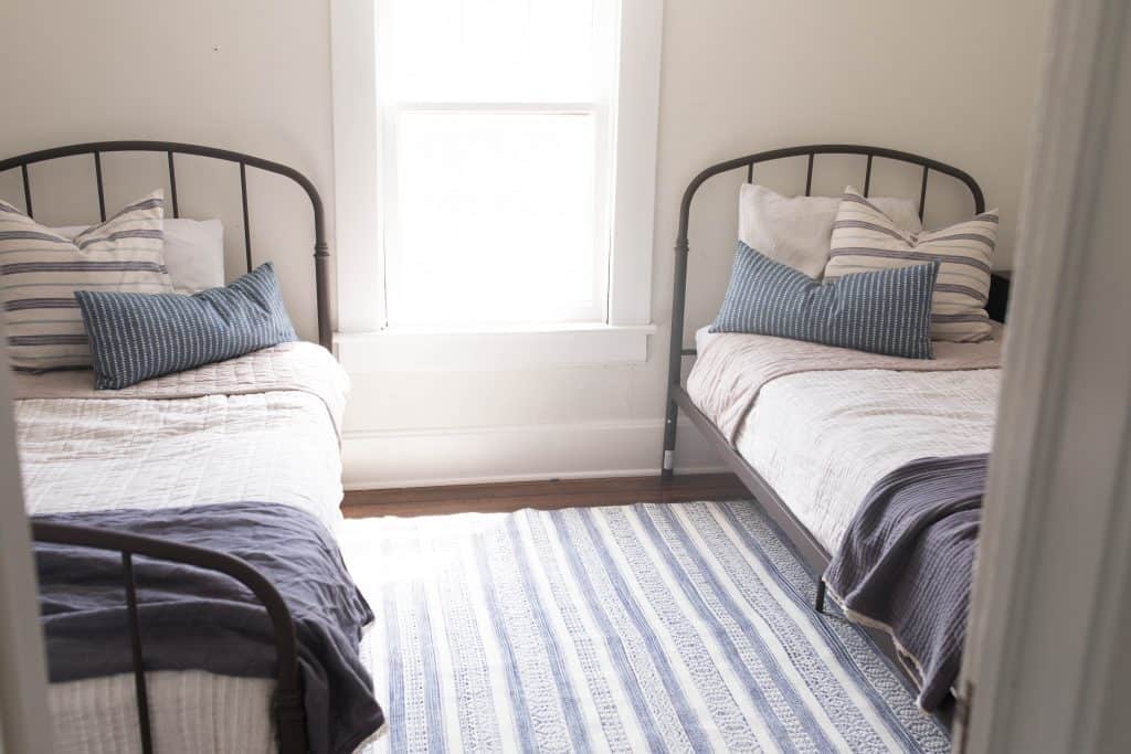 farmhouse boys room makeover iron beds blue tan ticking stipe benjamin moore soft chamois