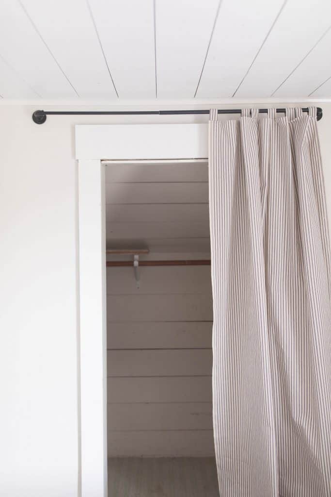 closet with a curtain shiplap ticking stripe farmhouse style 