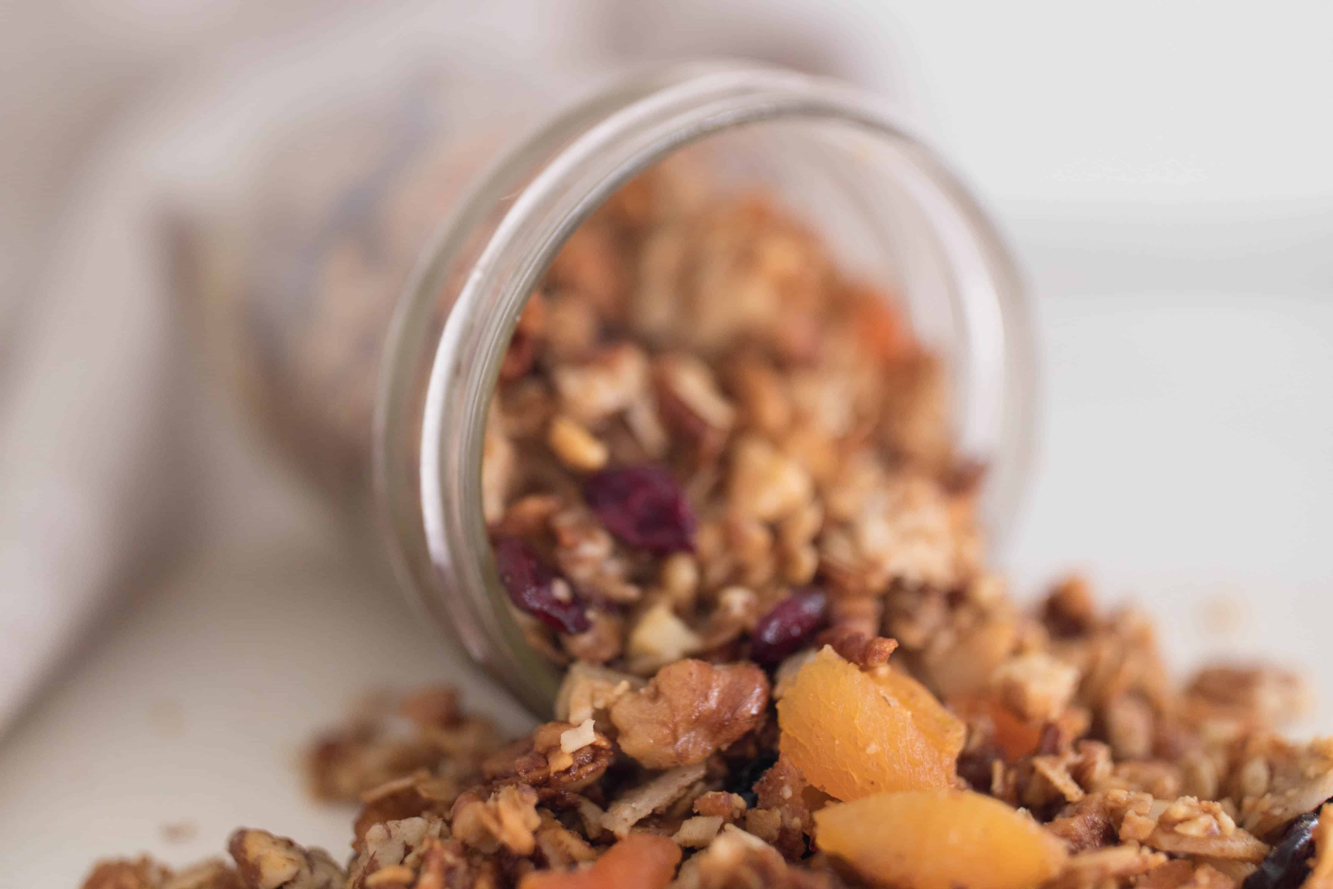 Granola in a mason jar tipped over and pouring out.