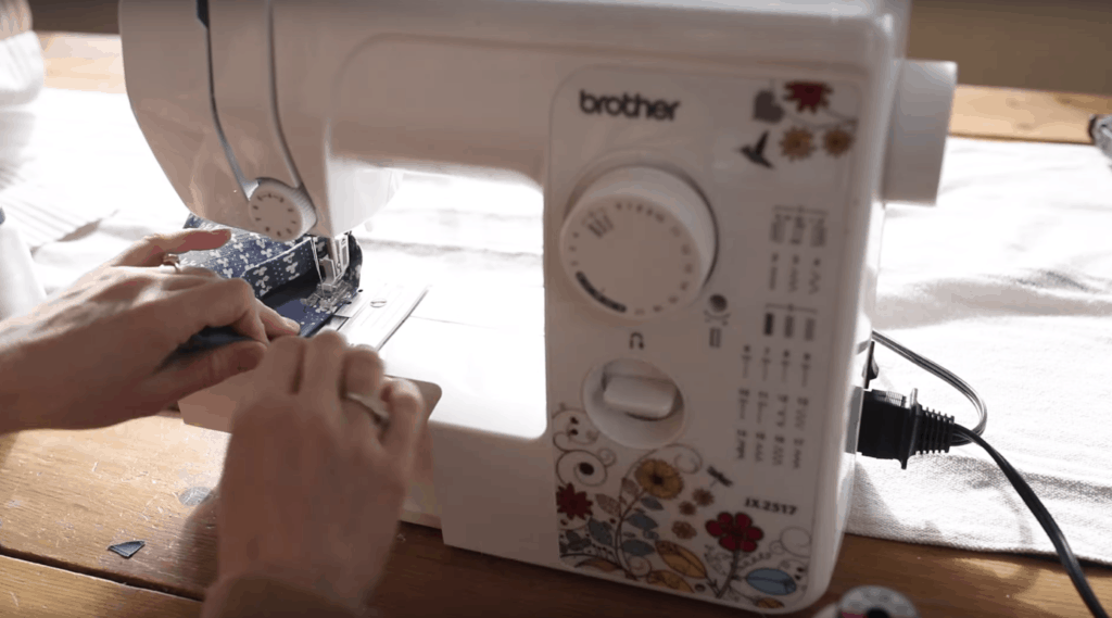 sewing the hem on a white sewing machine with flowers