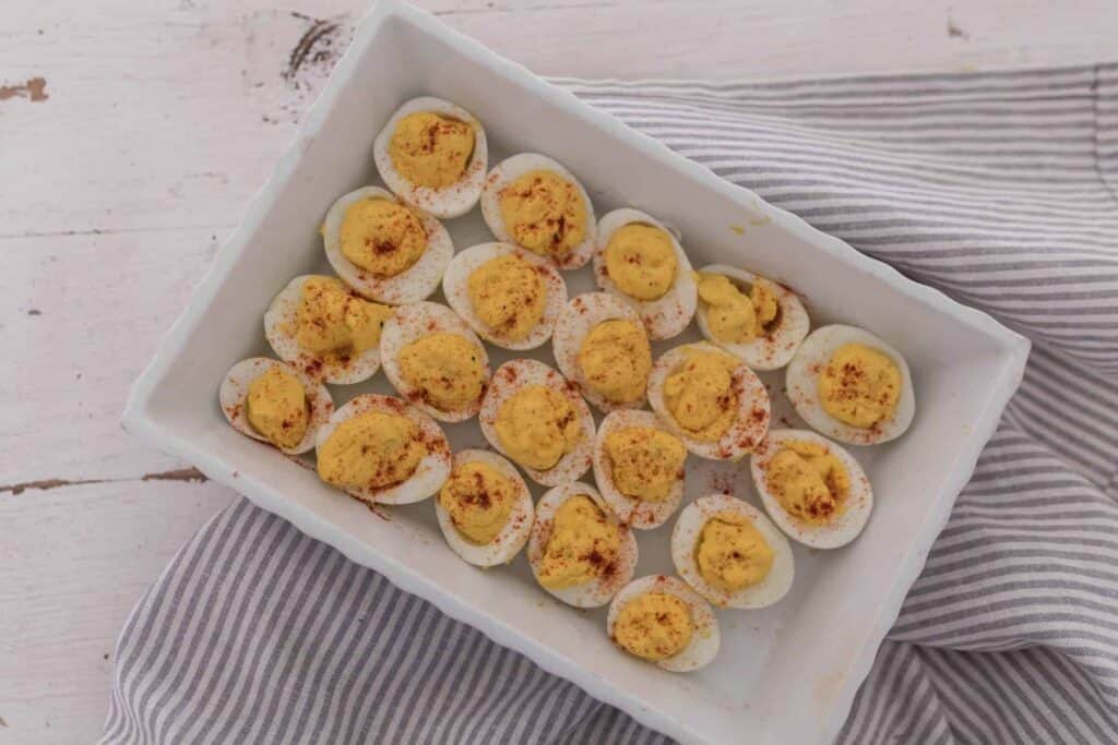 deviled eggs on a white platter on top a blue and white stripped towel - Instant Pot hard boiled eggs 