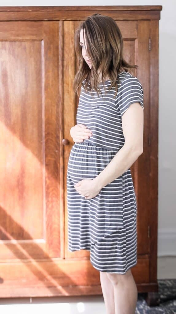 women wearing a stripped maternity dress for maternity capsule wardrobe