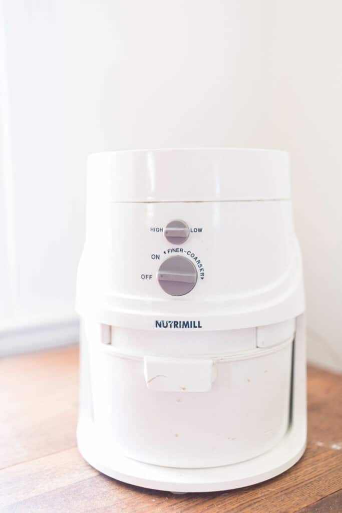 nutrimill grain mill on a wood countertop