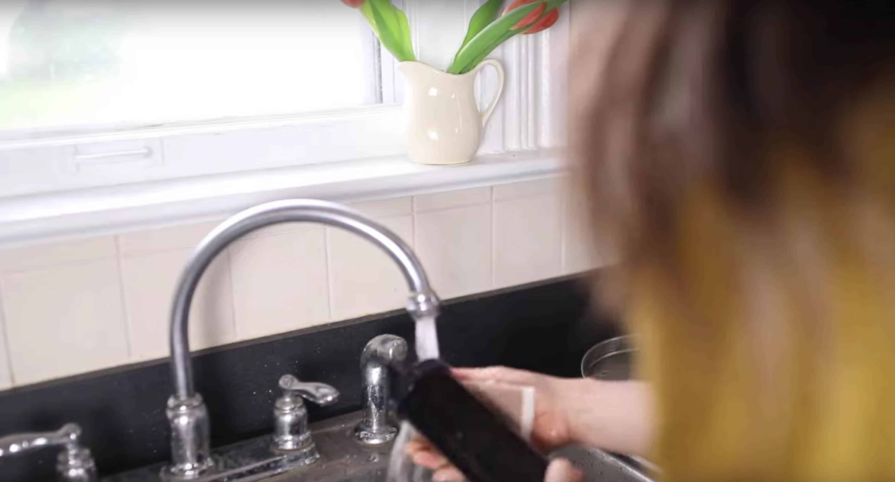 A woman washing a Boroux filter in a sink.