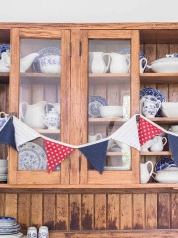 red white and blue bunting on hutch with china