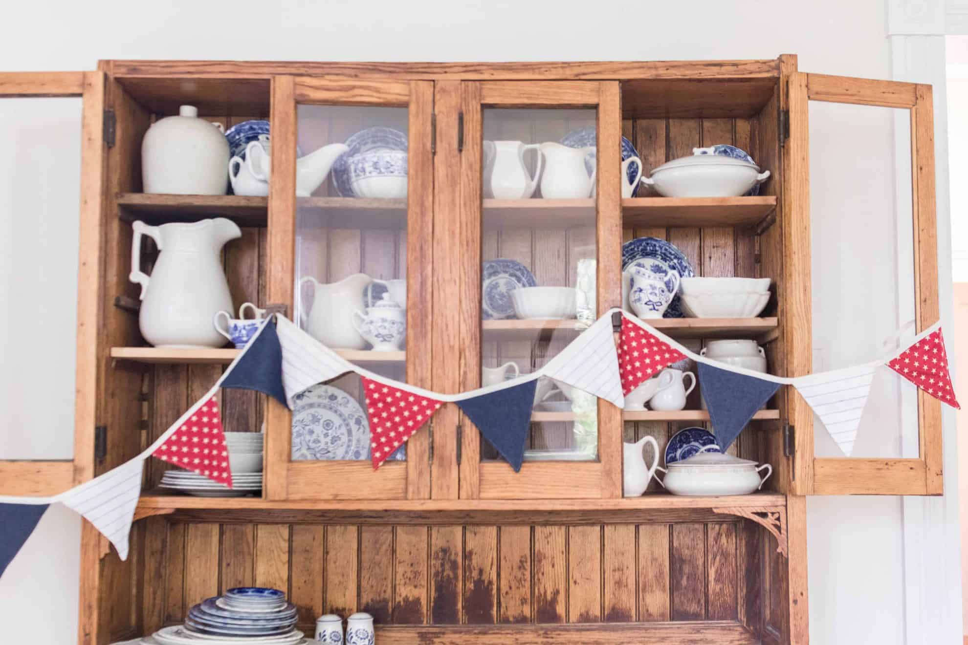 red white and blue bunting on hutch with china