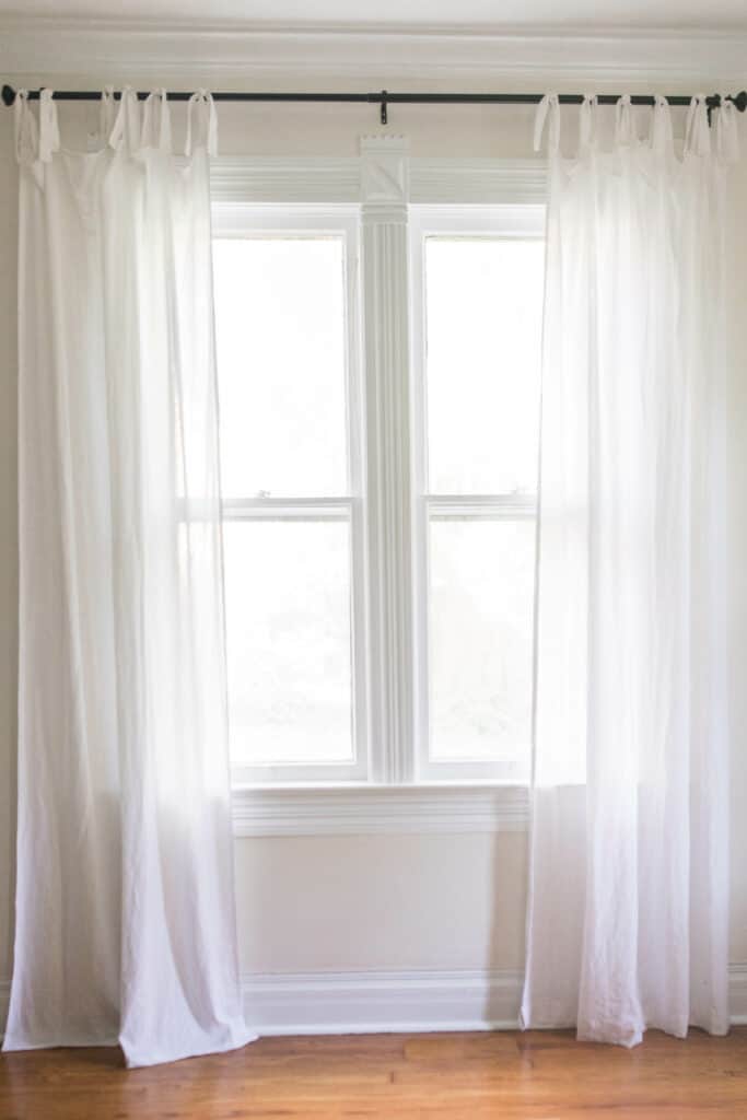 white tie top curtains hanging on a black curtain rod - how to make curtains tutorial