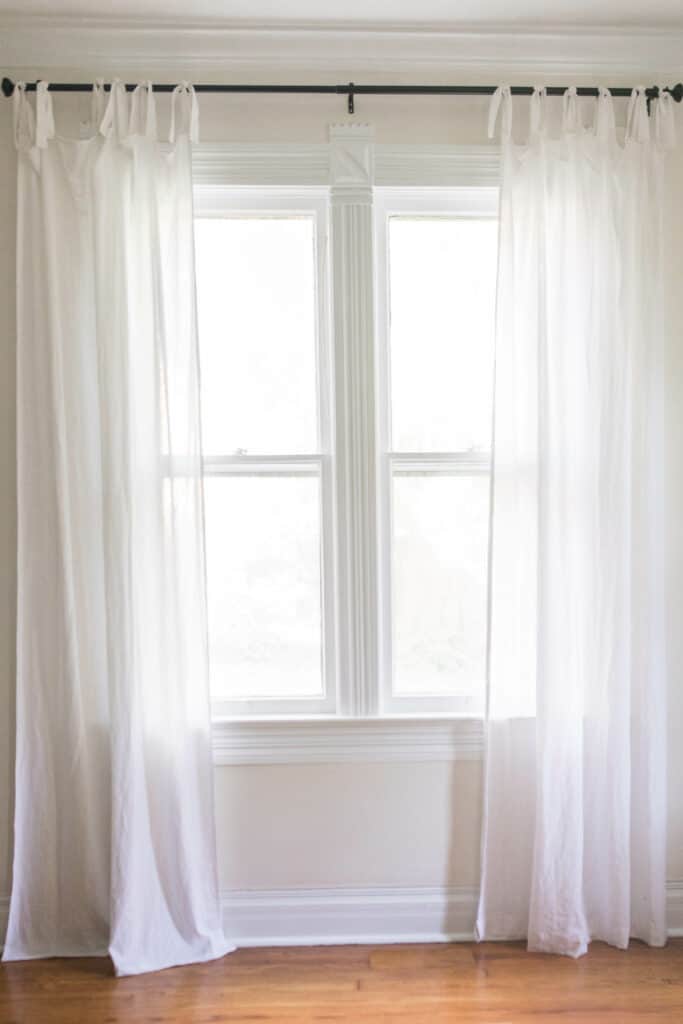 white tie top curtains hanging on a black curtain rod - how to make curtains tutorial