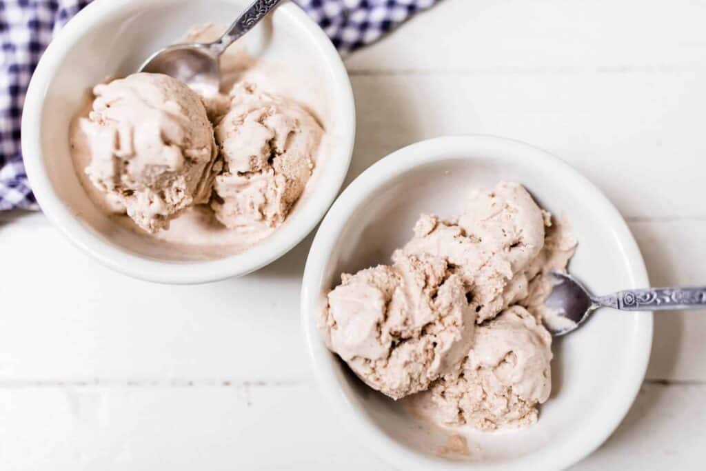 two bowls of pumpkin spice icecream on a white countertop with blue and white towel