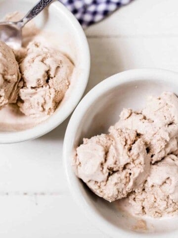 two bowls of pumpkin spice icecream on a white countertop with blue and white towel