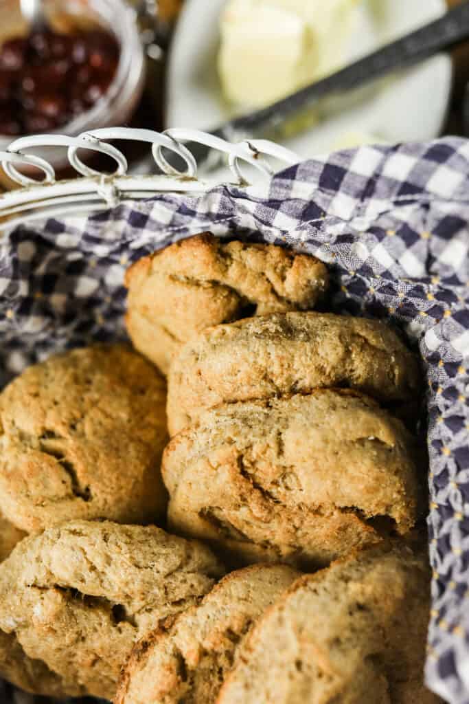 long fermented sourdough biscuits in a basket lined with a blue and white checked towel