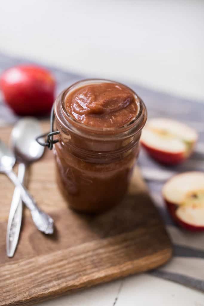 apple butter in mason jar on cutting board 