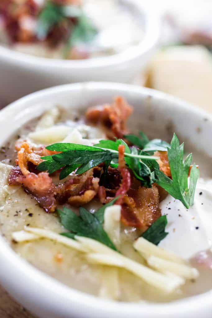 close up pictures of potato soup topped with cheese, parsley and bacon