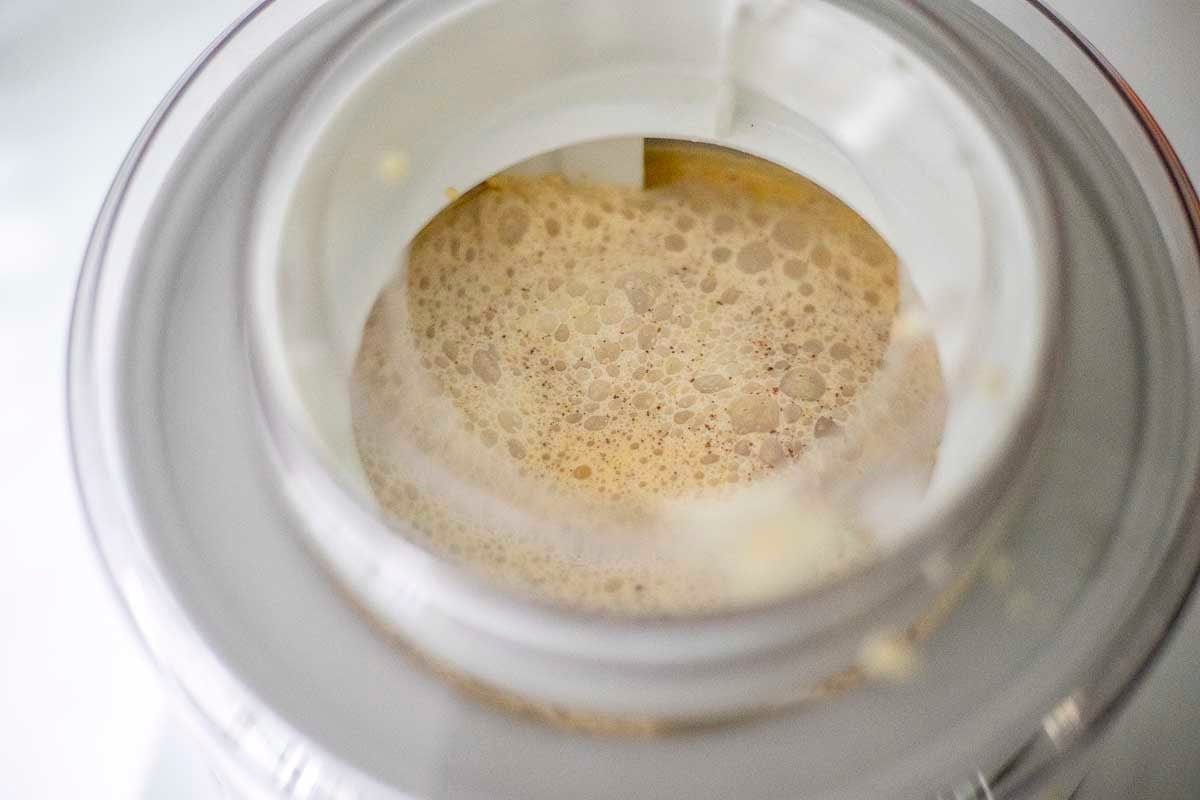 Pumpkin spice ice cream poured into an ice cream maker.