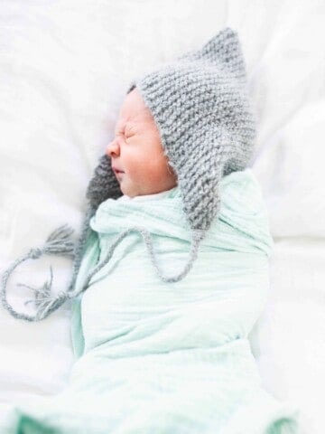 picture of baby with knit hat and swaddle blanket