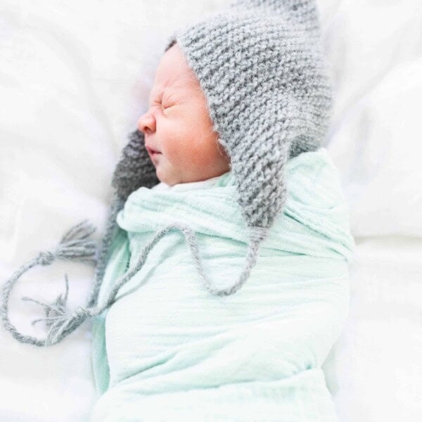 picture of baby with knit hat and swaddle blanket