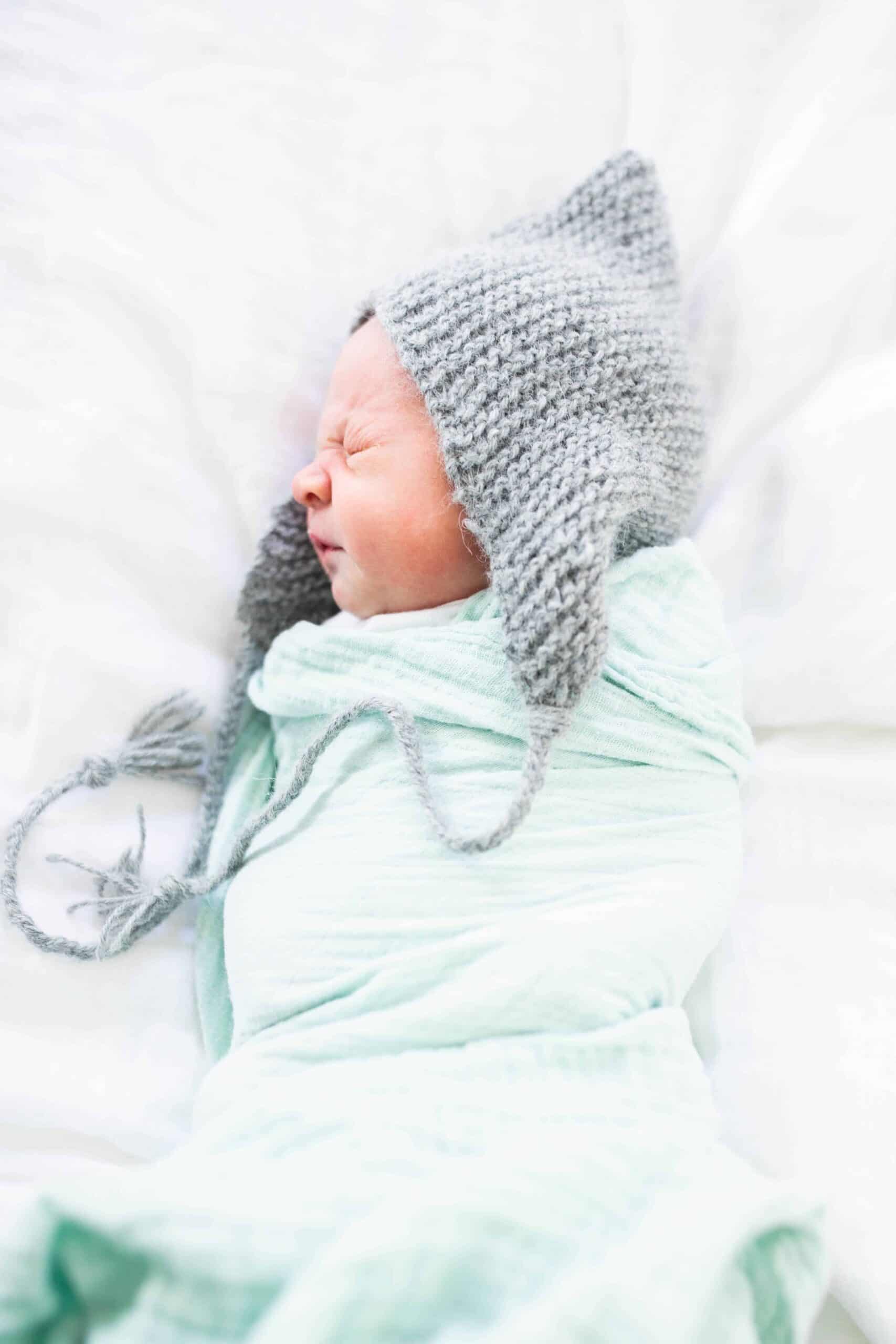 picture of baby with knit hat and swaddle blanket