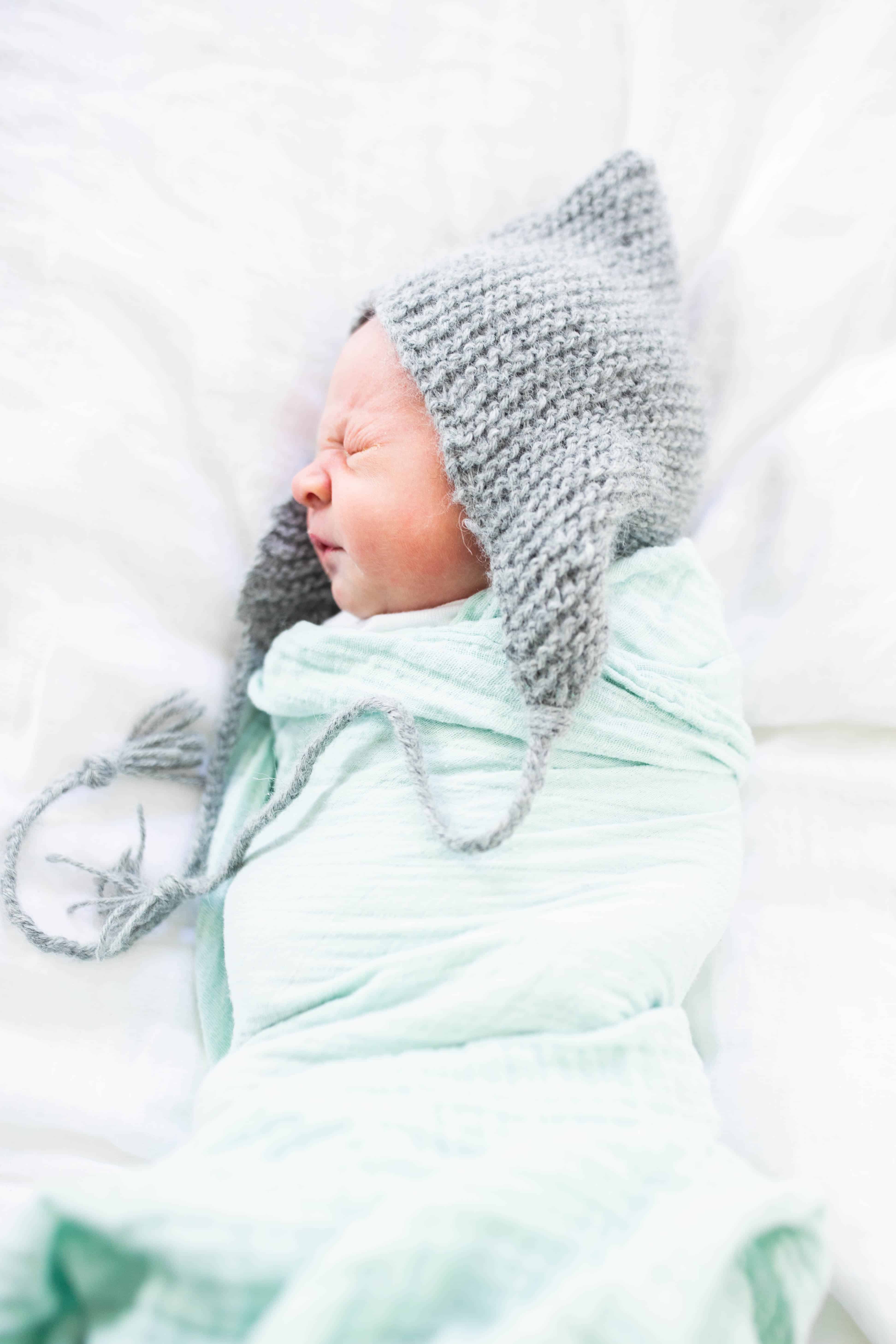 picture of baby with knit hat and swaddle blanket