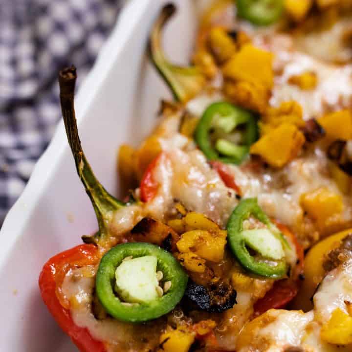 baking dish full of stuffed bell peppers with ground beef and topped with cheese and jalepenos