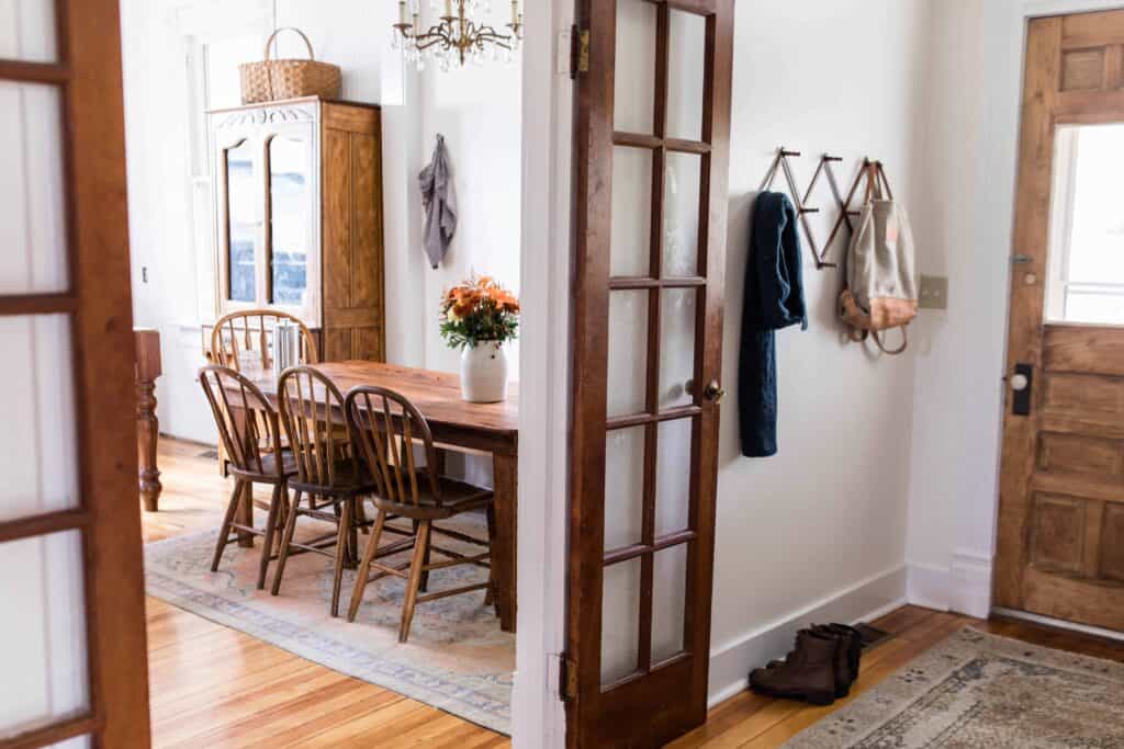 French doors to the eat-in kitchen are opened and showing gorgeous antique furniture