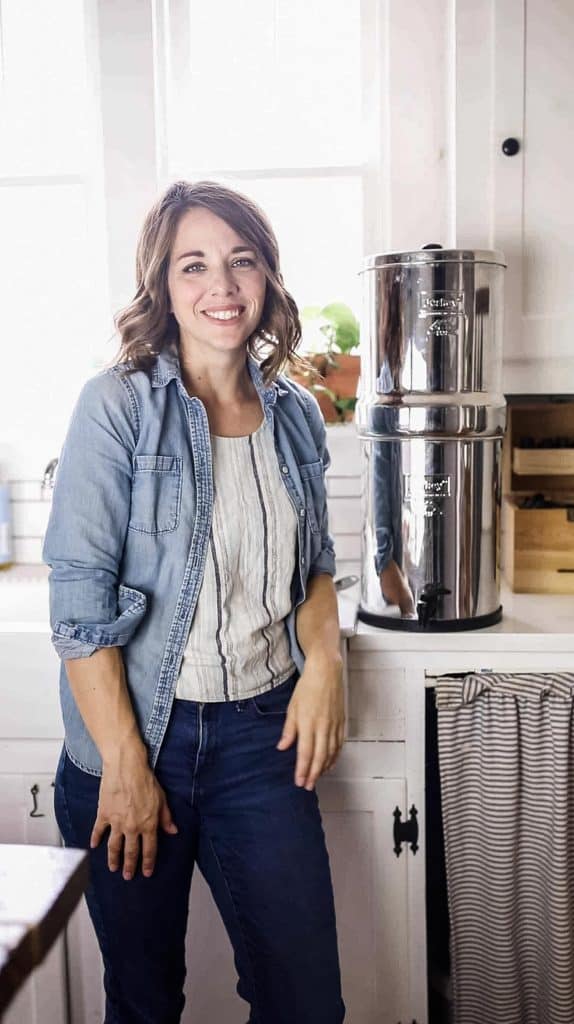 women standing next to Berkey water filter in her farmhouse kitchen