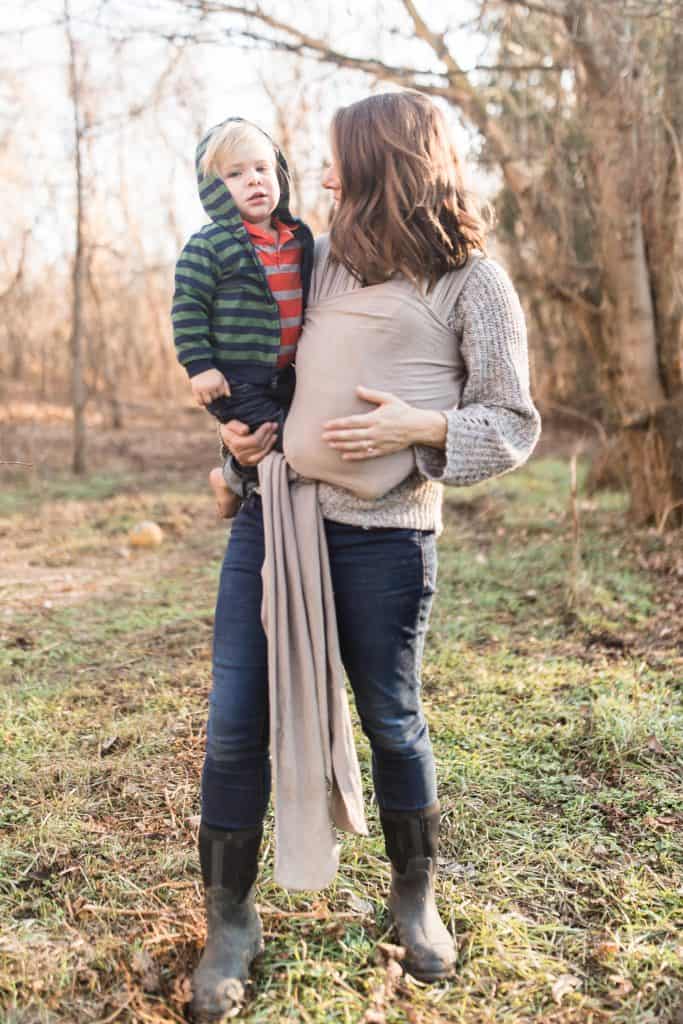 mom holding a small child white baby wearing her child