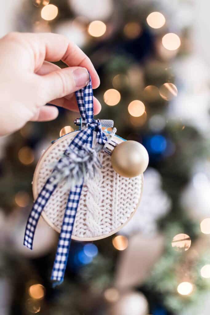 hand holding a Diy Christmas ornament made from embroidery hoop and a thrifted sweater